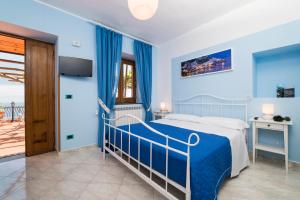 1 dormitorio azul con 1 cama y balcón en Residence Gioia, en Furore