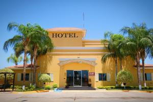 a hotel with palm trees in front of it at Zar Los Mochis in Los Mochis