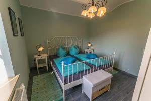 ein kleines Schlafzimmer mit einem Bett mit blauen Kissen in der Unterkunft Ferienwohnungen Endler in Bad Schandau