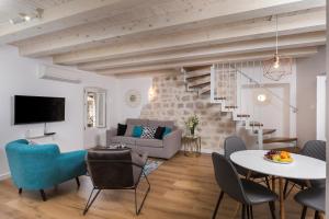 un soggiorno con divano, tavolo e sedie di Apartment Stulli 2 a Dubrovnik