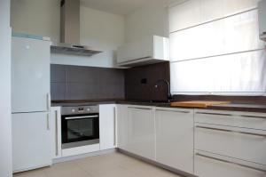 a white kitchen with white cabinets and a sink at Apartment Spanjol in Banjol