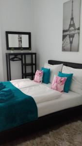 ブダペストにあるPalace Residenceのピンクとブルーの枕とエッフェル塔付きのベッド