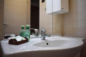 un lavandino in bagno con 2 bottiglie e uno specchio di Lake moments a Peschiera del Garda