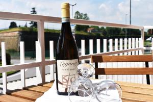 una bottiglia di vino appoggiata su un tavolo con dei bicchieri di Lake moments a Peschiera del Garda Altre 15 foto