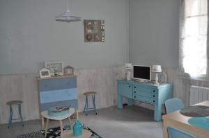a bedroom with a blue dresser and a desk with a computer at Le studio d'Ahynoa in Lauzun