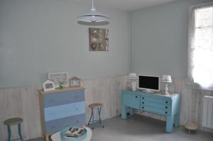 a room with a desk with a computer and a blue dresser at Le studio d'Ahynoa in Lauzun