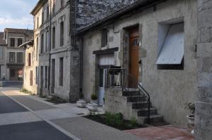 an old building with a staircase leading to a door at Le studio d'Ahynoa in Lauzun