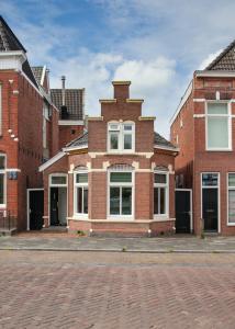 a brick building with white windows on a street at Skipper 4 - 3 bedroom authentic detached house in City Center in Groningen