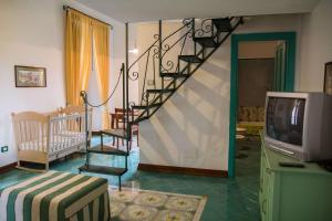 ein Wohnzimmer mit einer Wendeltreppe und einem TV in der Unterkunft Hotel Del Sole Al Plebiscito in Sapri