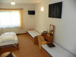 a small room with two beds and a desk at Dom Goscinny Andy in Pobierowo