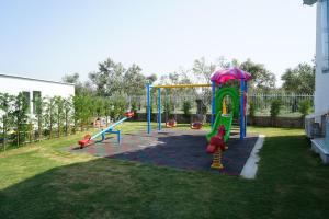 un patio con parque infantil y equipo de juegos en Zeytin Arası Apart Otel en Ayvalık