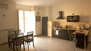 a kitchen with a table and chairs and a refrigerator at Casa Duomo in Aversa