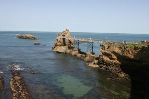 un puente sobre el océano con gente caminando sobre él en Le Gamaritz en Biarritz