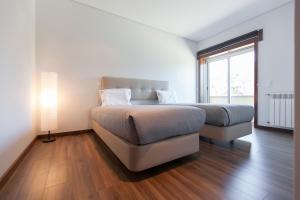 a bedroom with two beds and a lamp at Premium apart - Praia do Furadouro in Ovar +31 photos