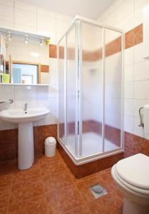 a bathroom with a shower and a sink and a toilet at Apartments Villa Concept in Poreč