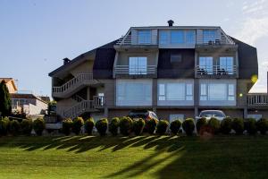 a large house with a lawn in front of it at Hotel Brisa in A Lanzada