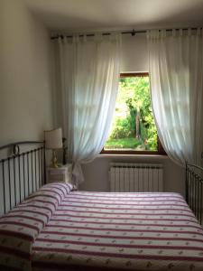 Un dormitorio con una cama grande y una ventana en Il Boscaccio, en Camaiore