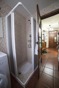 a shower with a glass door in a bathroom at Casa Rural Calecha in Caboalles de Abajo
