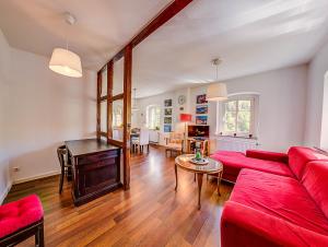 uma sala de estar com um sofá vermelho e uma mesa em Kutscherhaus Monschau em Monschau