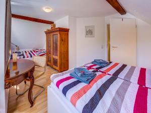 ein Schlafzimmer mit einem Bett mit einem Tisch und einem Stuhl in der Unterkunft Kutscherhaus Monschau in Monschau