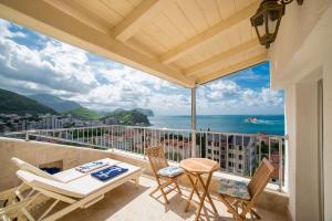 a balcony with a table and chairs and the ocean at Medin Apartments BluVista in Petrovac na Moru