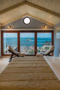 um quarto com uma cama grande e vista para o oceano em Medin Apartments BluVista em Petrovac na Moru