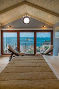 1 dormitorio con 1 cama grande y vistas al océano en Medin Apartments BluVista, en Petrovac na Moru