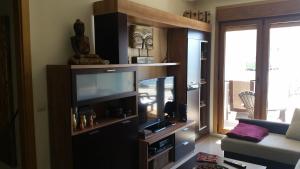 a living room with a large entertainment center with a flat screen tv at Apartamento La Cantera in Combarro