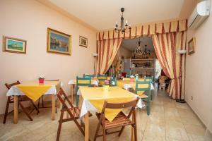 a dining room with yellow tables and chairs at Villa Liburnia in Livorno