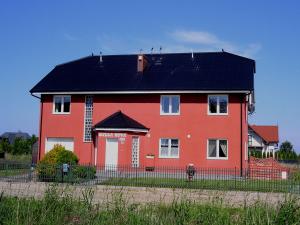 una gran casa roja con techo negro en Willa Nova, en Karwia