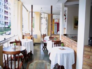 Pousada Bariloche في تيريسوبوليس: مطعم بطاولات بيضاء وكراسي ونوافذ