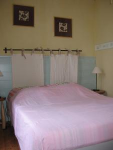 a bedroom with a large bed with pink sheets at La Vallée in Le Mont-Dore