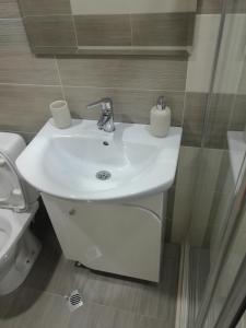 a bathroom with a white sink and a toilet at Forest Apartment in Sapareva Banya