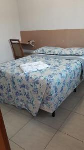 1 dormitorio con 1 cama con manta azul y blanca en Hotel New, en Formosa