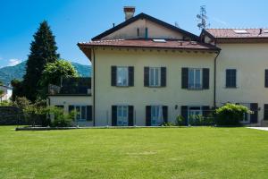 a large house with a green lawn in front of it at Giardino delle Ortensie in Cannobio