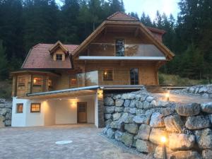 a house with a stone wall in front of it at Chalet Sodamin Alpin mit Wellness in Hohentauern