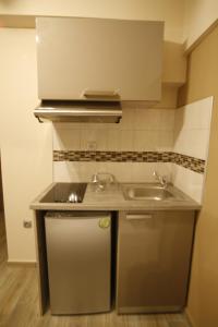 una pequeña cocina con fregadero y encimera en LDG Rooms, en Olympiakí Aktí