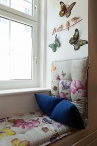 een bed met vlinders aan de muur naast een raam bij Karmeliter Home in Wenen