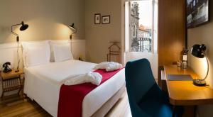a bedroom with a white bed and a desk and a window at Porto A.S. 1829 Hotel in Porto