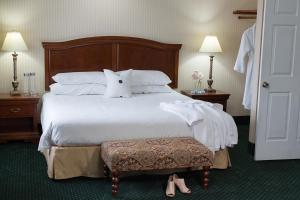 a hotel room with a large bed with a pillow at Rogue Regency Inn & Suites in Medford