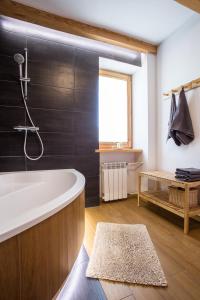 a bathroom with a bath tub and a window at Apartament pod Lawortą in Ustrzyki Dolne