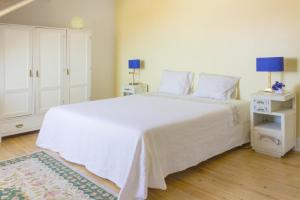um quarto com uma cama branca e um armário branco em Casa Coimbra em Coimbra