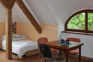 a bedroom with a table and a bed and a window at Pałac Ogrodowa in Tarnowskie Góry