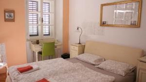 Schlafzimmer mit einem Bett, einem Schreibtisch und einem Spiegel in der Unterkunft In the center & nice & quiet in Pula