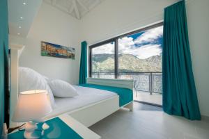 a bedroom with a bed and a large window at StOliva RESIDENCE with infinity pool in Kotor