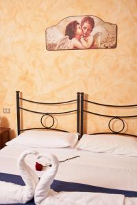 Un dormitorio con una cama con dos cisnes. en Agriturismo La Piana, en Castiglione del Lago