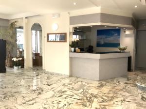 a lobby with a marble floor and a counter at Hôtel Le Dauphin in Menton