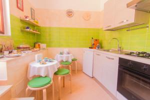 a kitchen with two tables and green tiles at B&B Sotto un Tetto in Cetara