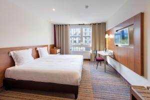 um quarto de hotel com uma cama grande e uma janela em Hotel Lyon-ouest em Lyon mais 28 fotografias