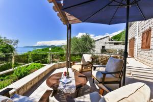 a patio with a table and chairs and an umbrella at Villa Rijeka Rezevici in Petrovac na Moru